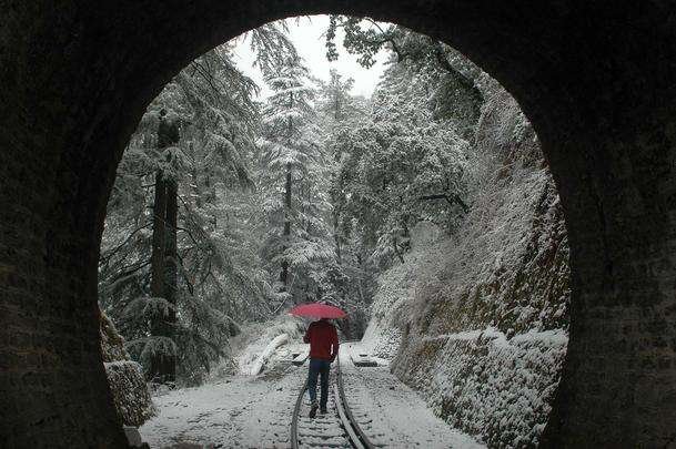 Um homem caminha ao longo de uma ferrovi�ria em Shimla (�ndia) coberta pela neve - AFP PHOTO / STR 