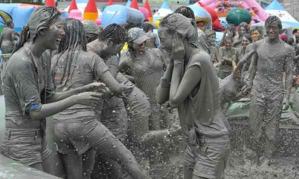 Turistas se divertem no 15º Festival de Lama em Seul. O festival anual visa incentivar o uso de lama para cuidados da pele  - AFP PHOTO / KIM JAE-HWAN 