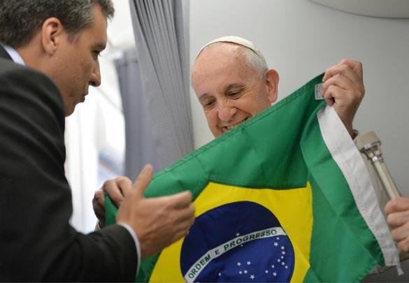Papa Francisco recebe a bandeira do Brasil antes de descer do avião, no aeroporto do Galeão - LUCA ZENNARO