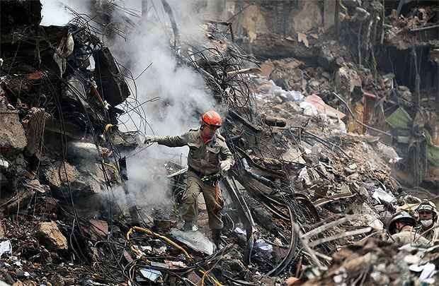 Bombeiro é visto durante as buscas no Centro do Rio (TOPSHOTS/AFP PHOTO/VANDERLEI ALMEIDA ) Bombeiro é visto durante as buscas no Centro do Rio (TOPSHOTS/AFP PHOTO/VANDERLEI ALMEIDA )