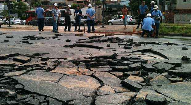 Ténicos da Copasa trabalham na avenida que teve o asfalto destruído pela pressão da água (Euler Junior/EM DA Press)