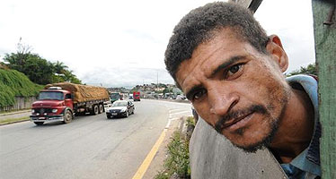 O servente Flávio na janela da cozinha do barraco em que mora no Anel Rodoviário, em Belo Horizonte: uma carreta já atingiu o local antes de ele se mudar para lá