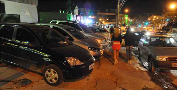 Pedestres se espremem na calçada que vira estacionamento na Raja Gabaglia, reduto de points da moda  (Marcos Vieira/EM/DA Press)