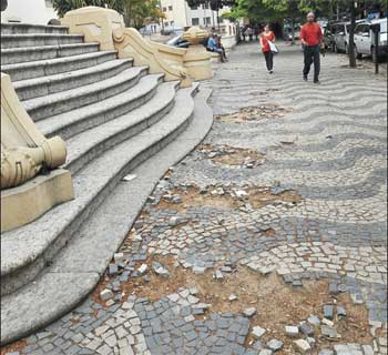 Em frente à Escola Pedro II, no Santa Efigênia, piso cheio de buracos e pedras soltas obrigam pedestres a desviar (Marcos Michelin/EM/D.A Press)