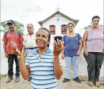 De joelhos: Nininha e outros moradores da comunidade de Quinta do Sumidouro agradecem pelo retorno da imagem ( BETO NOVAES/EM/D.A PRESS)