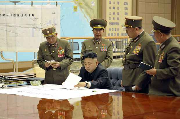 Líder norte-coreano Kim Jong-Un discute plano de ataque com agentes norte-coreanos durante uma reunião em local não revelado (KNS / KCNA / AFP)