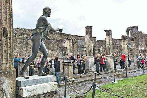 Turistas caminham pelas ruas de Pompeia: a cidade, destruída pelo Vulcão Vesúvio em 79 a.C., é uma rica fonte de informações sobre o cotidiano da antiguidade ( (Roberto Salomone/AFP - 27/10/11))