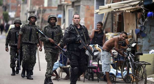 Policial guia militares por favela do complexo da maré, em preparação para a operação do exército (Sergio Moraes/REUTERS) Policial guia militares por favela do complexo da maré, em preparação para a operação do exército (Sergio Moraes/REUTERS)