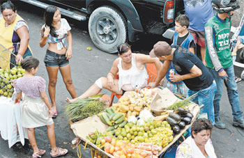Adolescentes abordam clientes para vender as rifas em barracas de frutas, peixes e verduras (Monique Rene / CB / DA Press) Adolescentes abordam clientes para vender as rifas em barracas de frutas, peixes e verduras (Monique Rene / CB / DA Press)