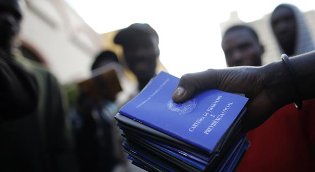 Homem mostra carteiras de trabalho emitidas para haitianos que estão abrigados na paróquia Nossa Senhora da Paz (Nacho Doce/Reuters) Homem mostra carteiras de trabalho emitidas para haitianos que estão abrigados na paróquia Nossa Senhora da Paz (Nacho Doce/Reuters)